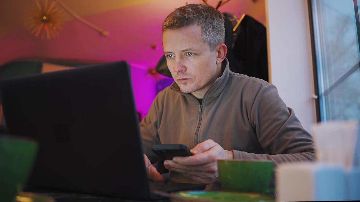 Merchant following a setup guide on laptop and phone
