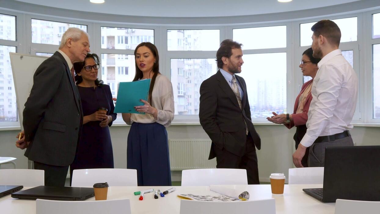 Colleagues talking in a bright office