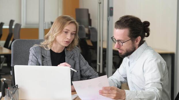 Two colleagues reviewing a store design on a laptop